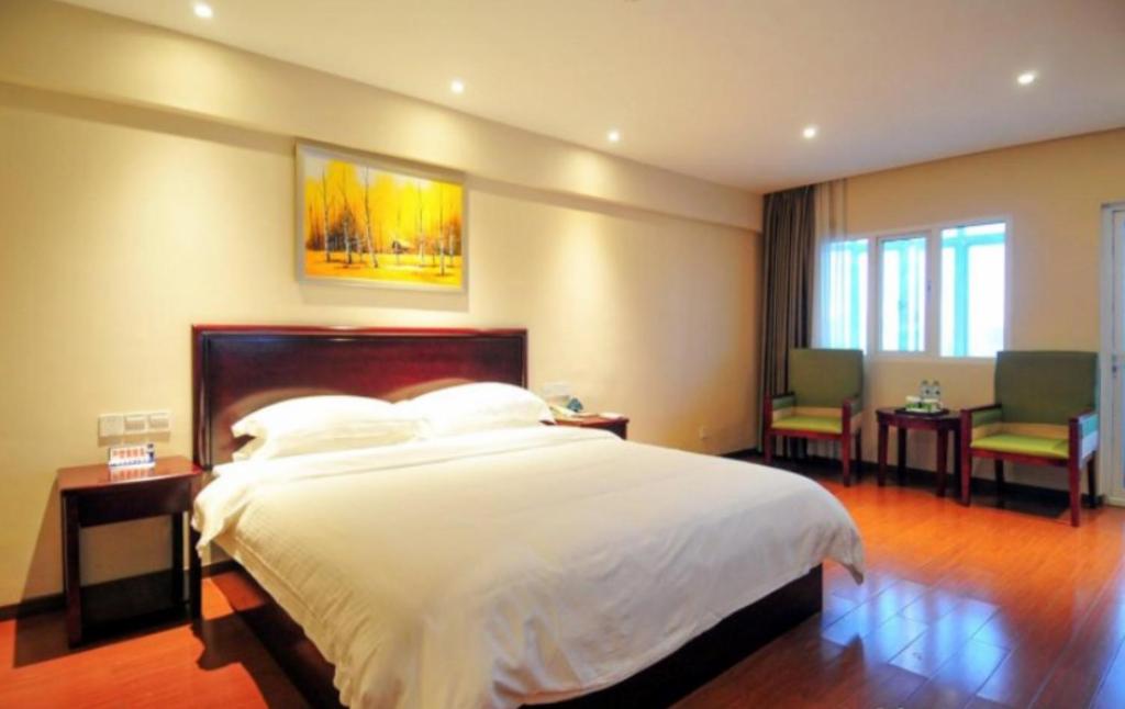 海口格林豪泰海南省海口海府路省政府快捷酒店的卧室配有一张床和一张桌子及椅子