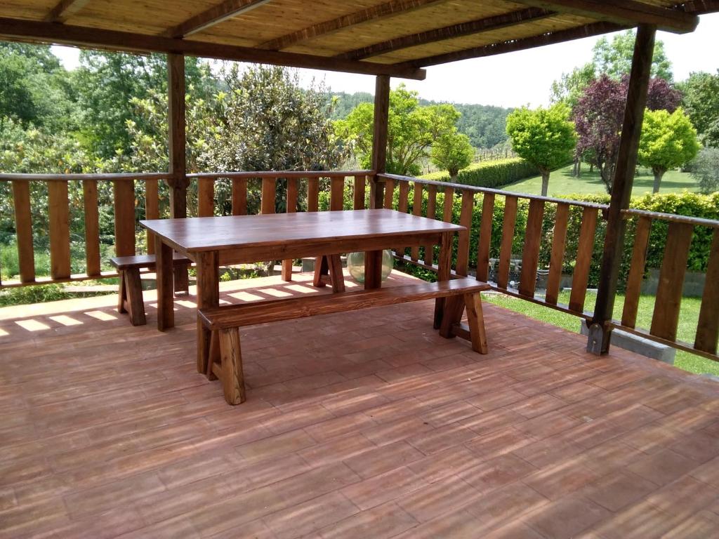 蓬泰代拉IL Poggio的木制甲板上配有桌子和长凳