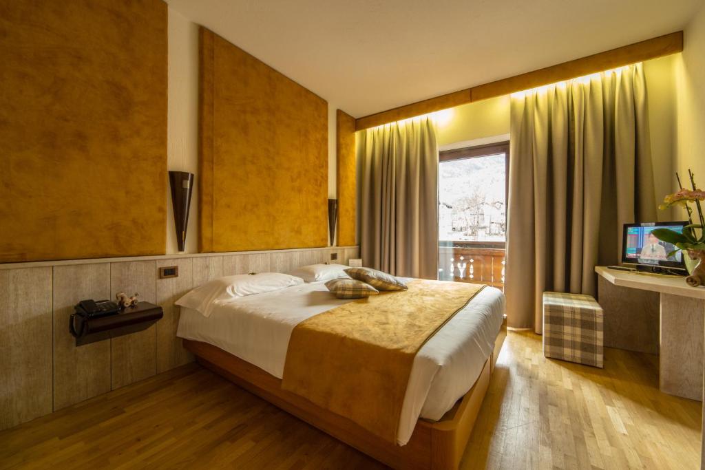 费尼斯Hotel Comtes De Challant Albergo Etico Valle d'Aosta的一间卧室配有一张大床和电视