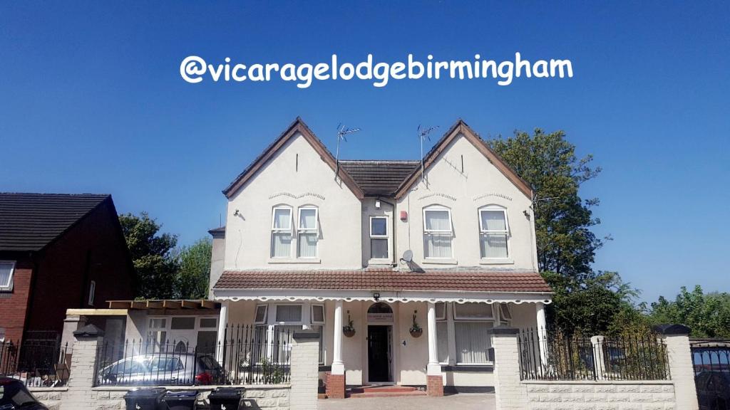 伯明翰Vicarage Lodge Birmingham的前面有栅栏的白色房子