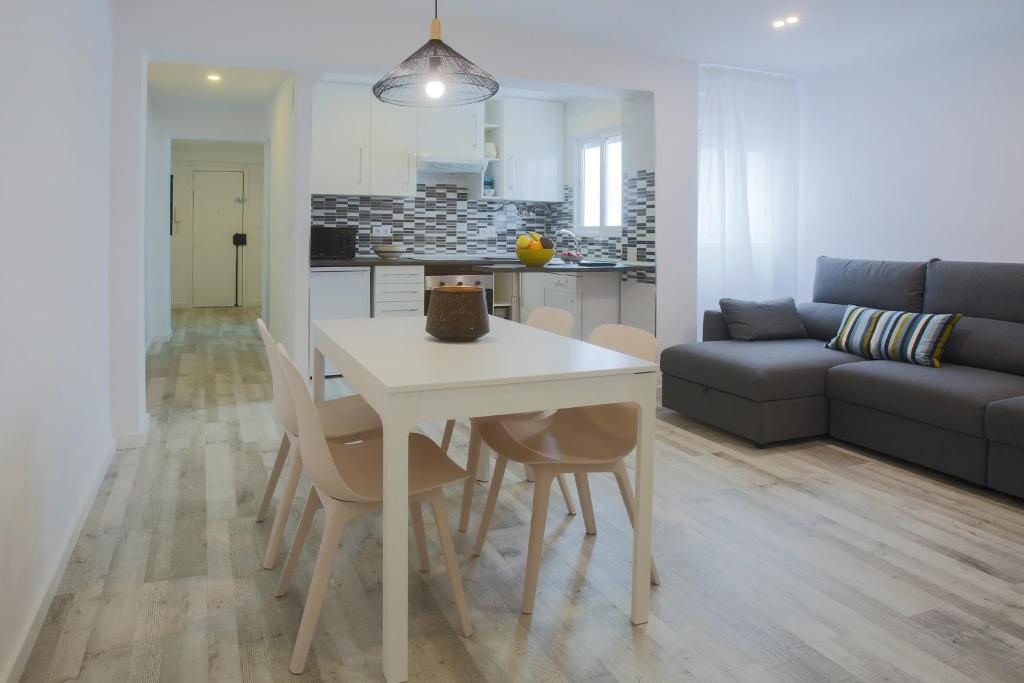瓦伦西亚Apartment Meraki Valencia的厨房以及带白色桌椅的起居室。