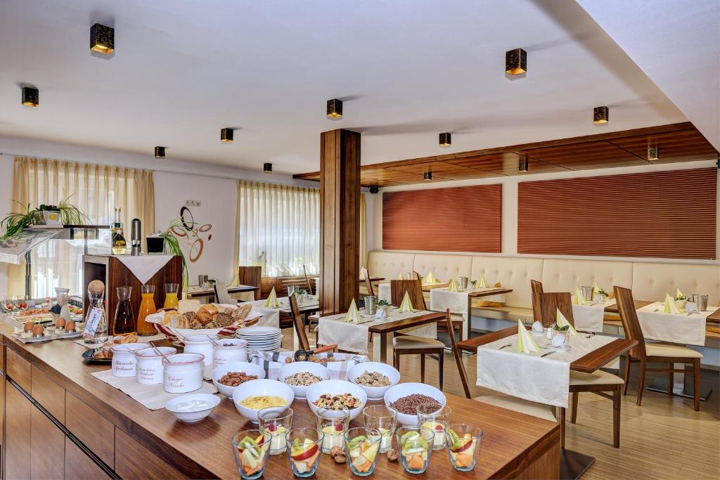 圣瓦伦蒂诺阿拉穆塔Garni Apparthotel St Valentin的一间用餐室,配有一张带食物盘的桌子