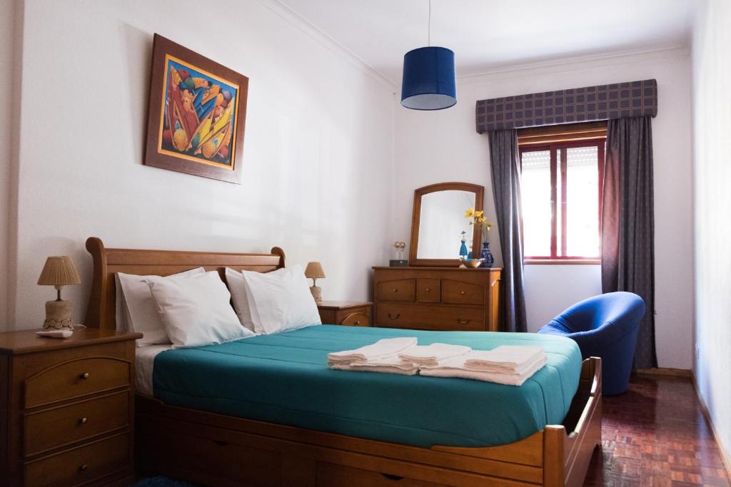 塔维拉Apartamento Tavira的一间卧室配有一张带蓝椅和镜子的床