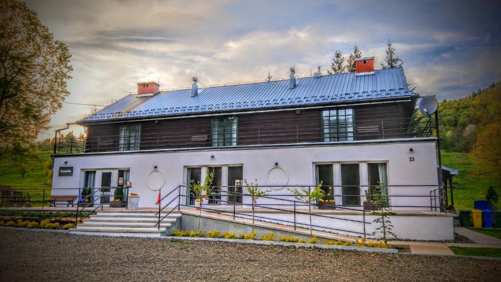 齐斯纳Leonówka Bieszczady的蓝色屋顶的大型白色房屋