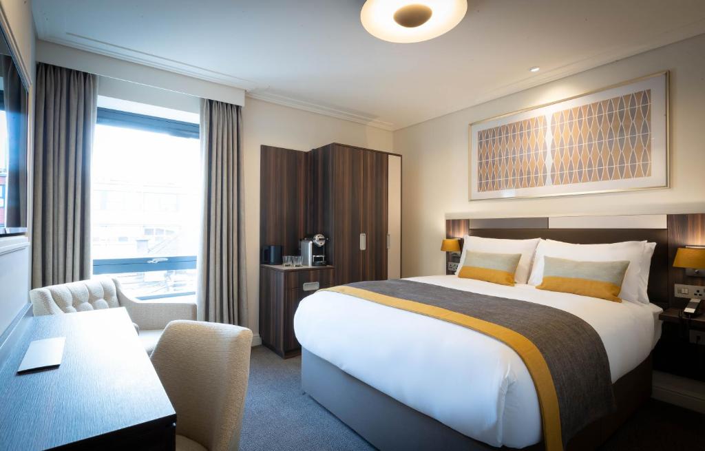 都柏林7号酒店的酒店客房设有一张大床和一张书桌。