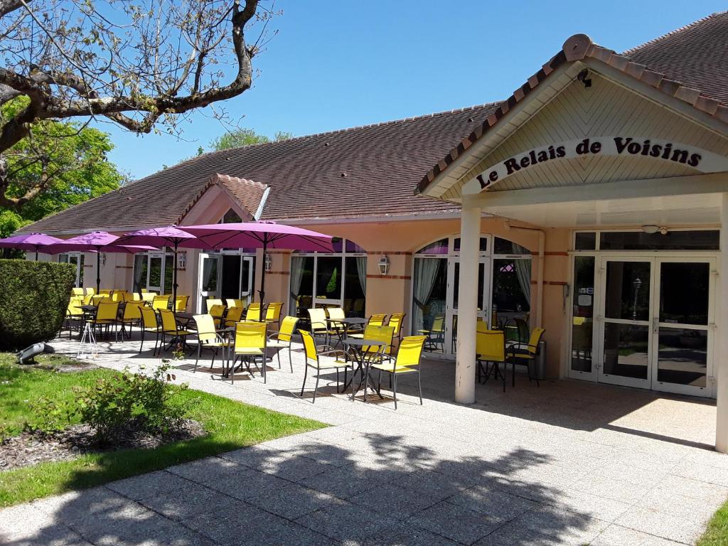 维尼森斯勒博特涅勒赫莱德瓦桑酒店 的一间带桌椅和紫色遮阳伞的餐厅