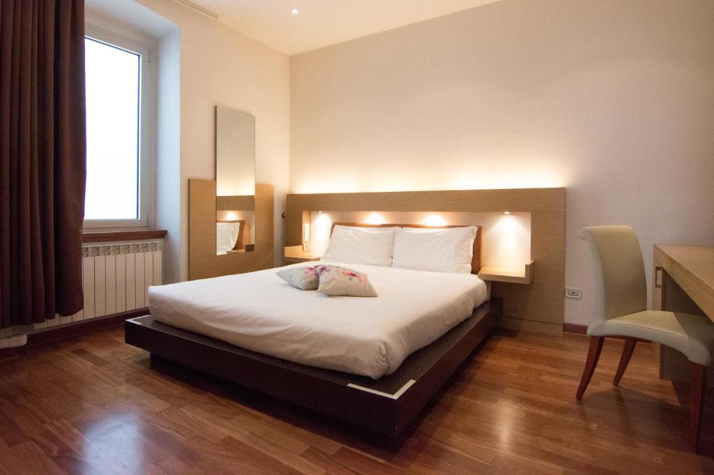 的里雅斯特维多利亚公寓式酒店的一间卧室配有一张大床和灯光