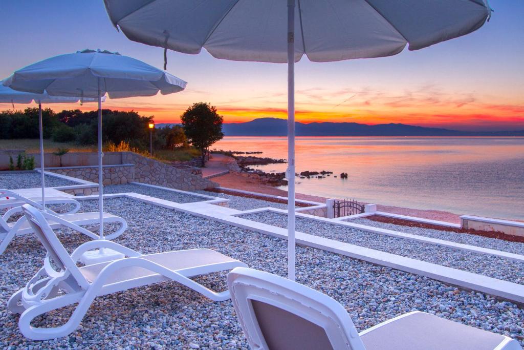 马林斯卡Luxury Apartments Villa Matea 1的海滩上的一组白色椅子和遮阳伞