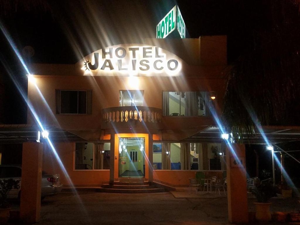 Aldea CamareroHotel Jalisco的一家在晚上在前面有标志的酒店