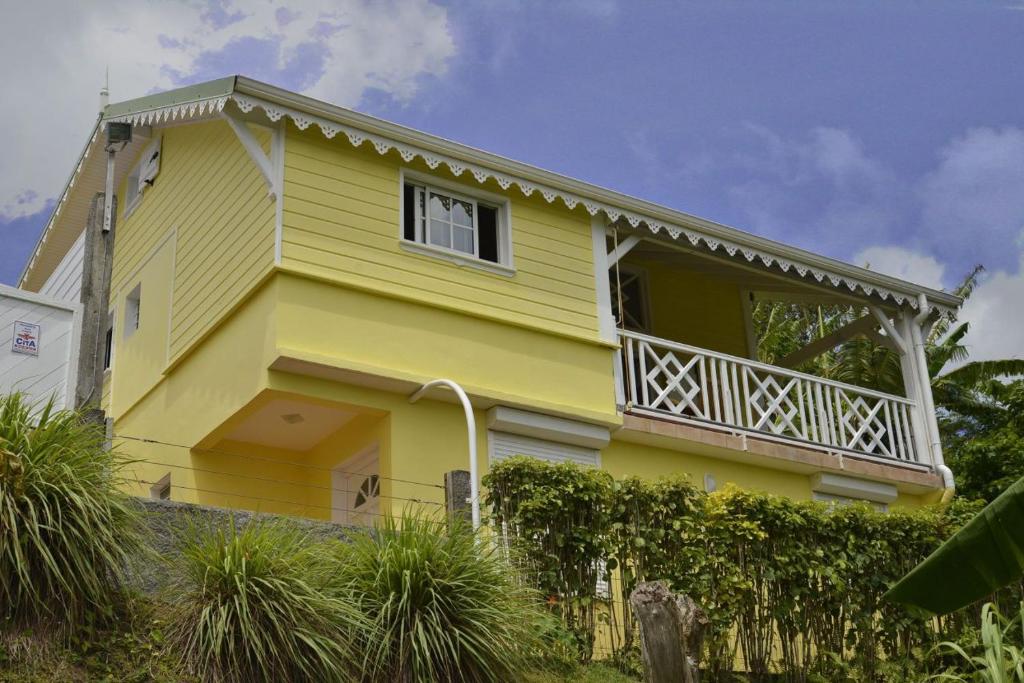 勒弗朗索瓦Résidence Kay Mamy Zèt的黄色房屋设有阳台和围栏