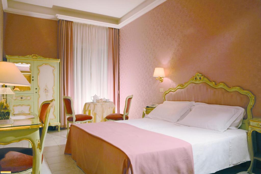 罗马罗姆鲁斯酒店的卧室配有白色的床和桌椅