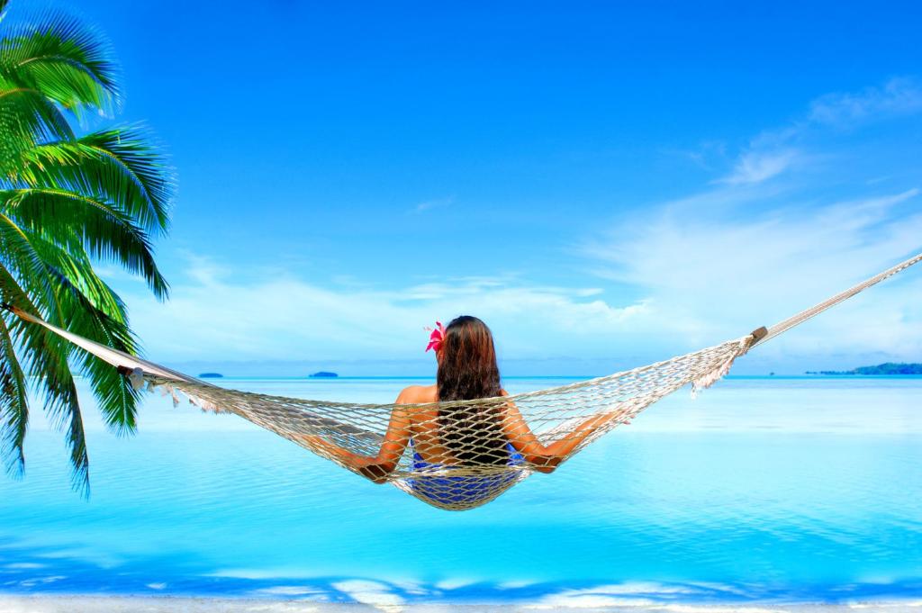 阿鲁坦加艾图塔基泻湖私人岛屿度假村（仅限成人）的坐在海滩上吊床上的女人