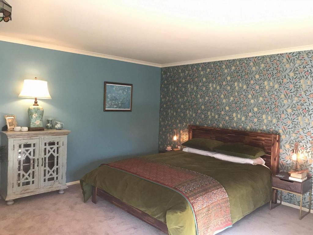 PateaGlascroft Gardens - Bed & Breakfast的一间卧室设有一张床和蓝色的墙壁