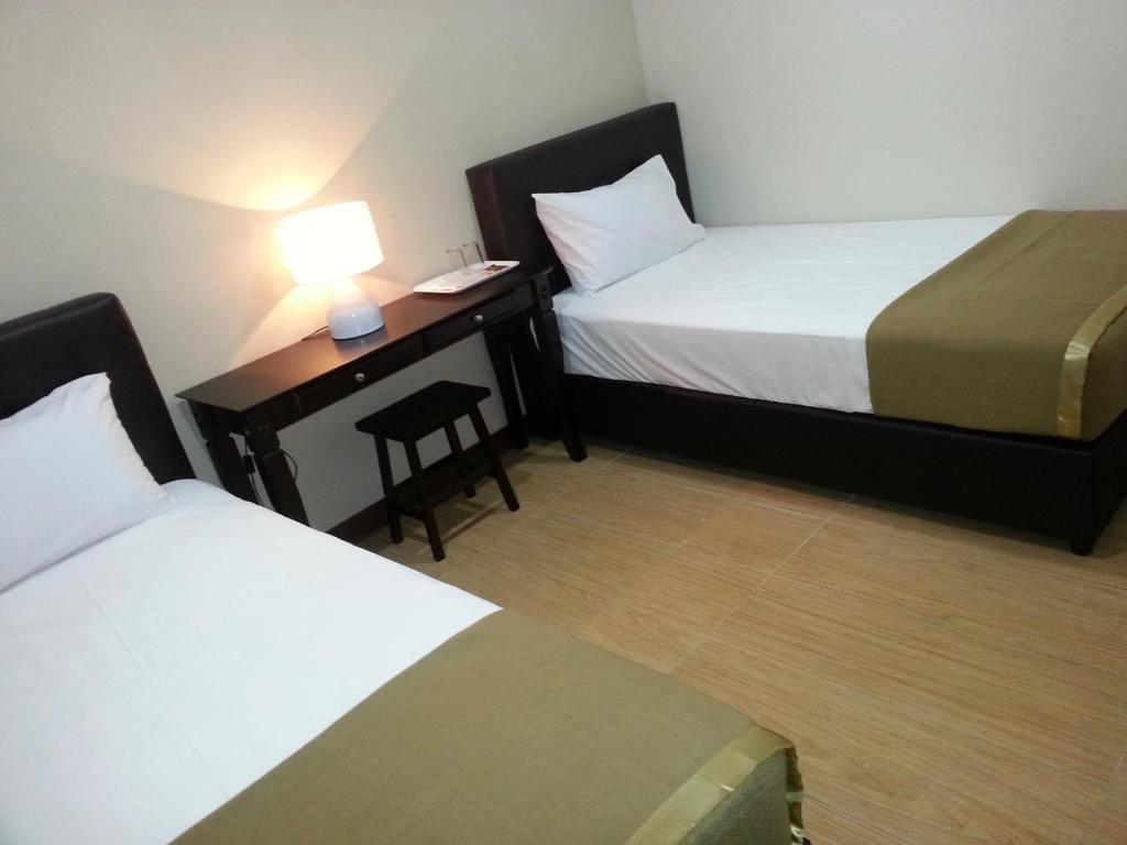 关丹法戈精品酒店的酒店客房配有两张床和一张带台灯的书桌