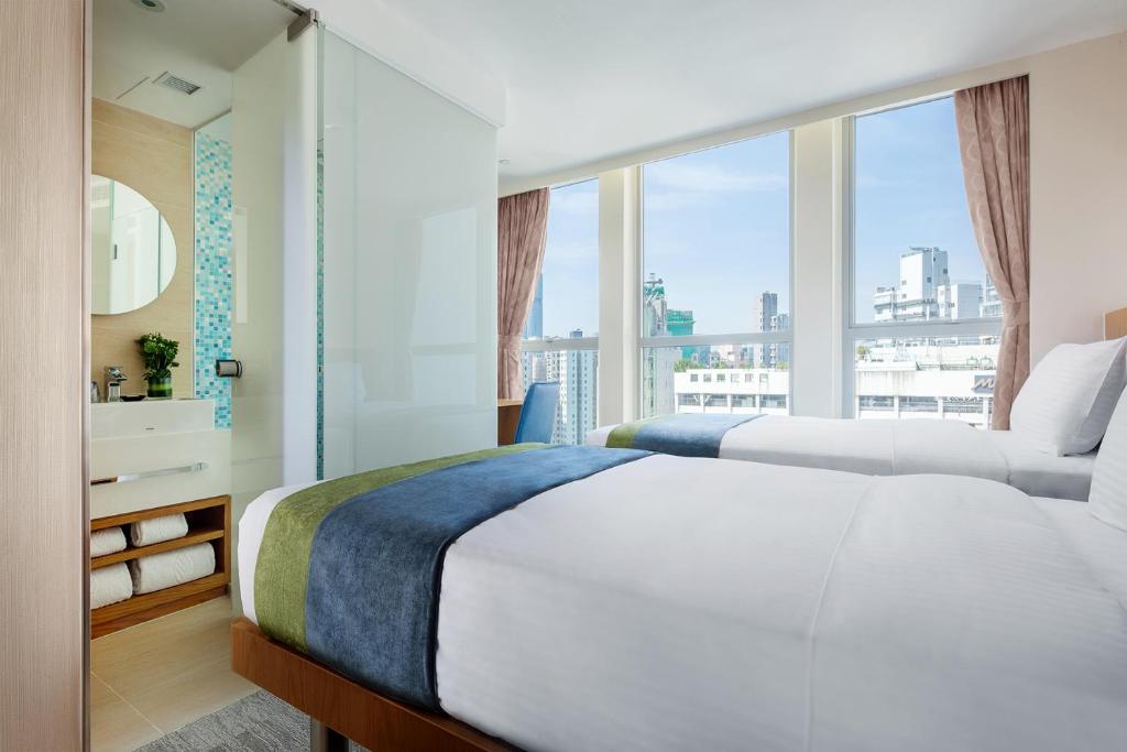 香港峰景轩的一间卧室设有两张床和大窗户