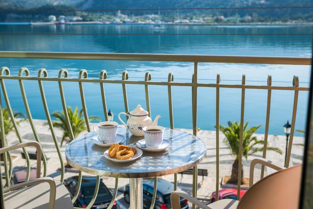 阿尔戈斯托利翁Tourist Boutique Hotel的阳台上的桌子上放着两杯茶和饼干
