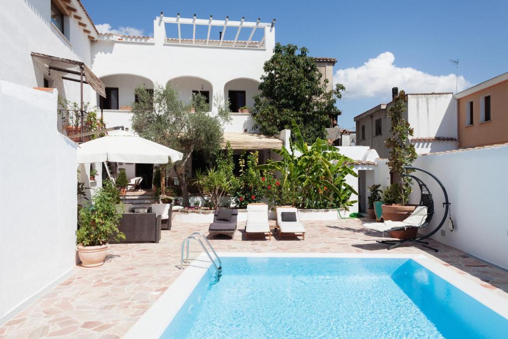 IrgoliGulf of Orosei Luxury Mediterranean House的庭院内的游泳池,有房子