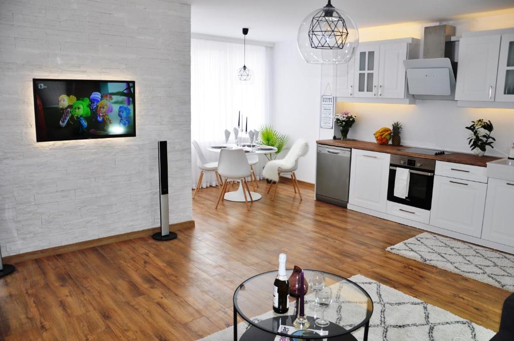 帕扎尔吉克Lux Apartment的厨房以及带桌子和电视的客厅。