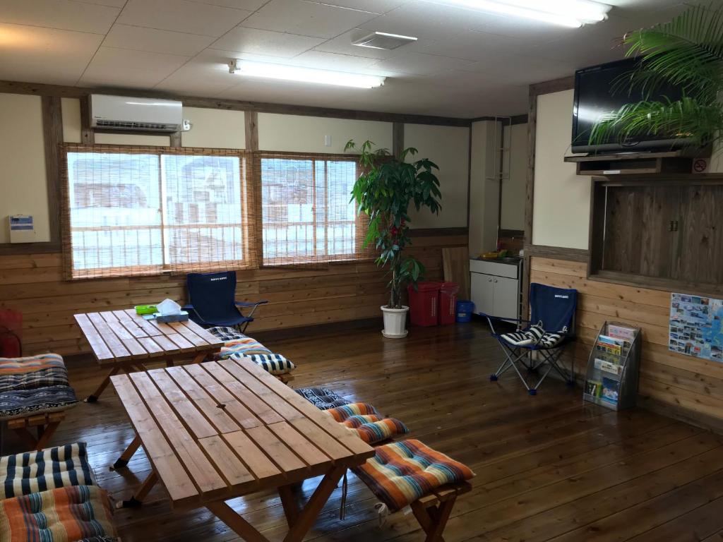 濑户内町Guesthouse Minami的客房设有桌椅和平面电视。