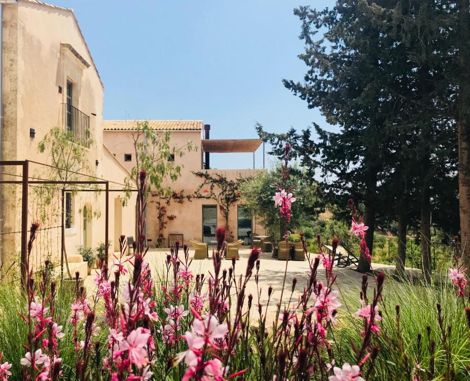 诺托Battimandorlo的一座花园,在一座建筑前方种有粉红色花卉
