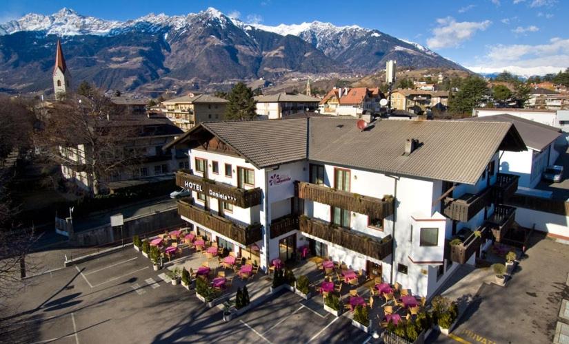 梅拉诺丹妮拉酒店的享有建筑的空中景观,以群山为背景
