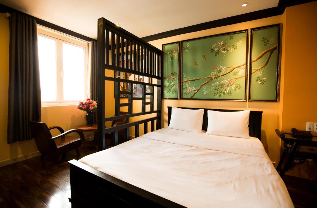 胡志明市Ipeace Hotel - Bùi Viện Walking Street的一间卧室配有一张带白色床单的床和一扇窗户。