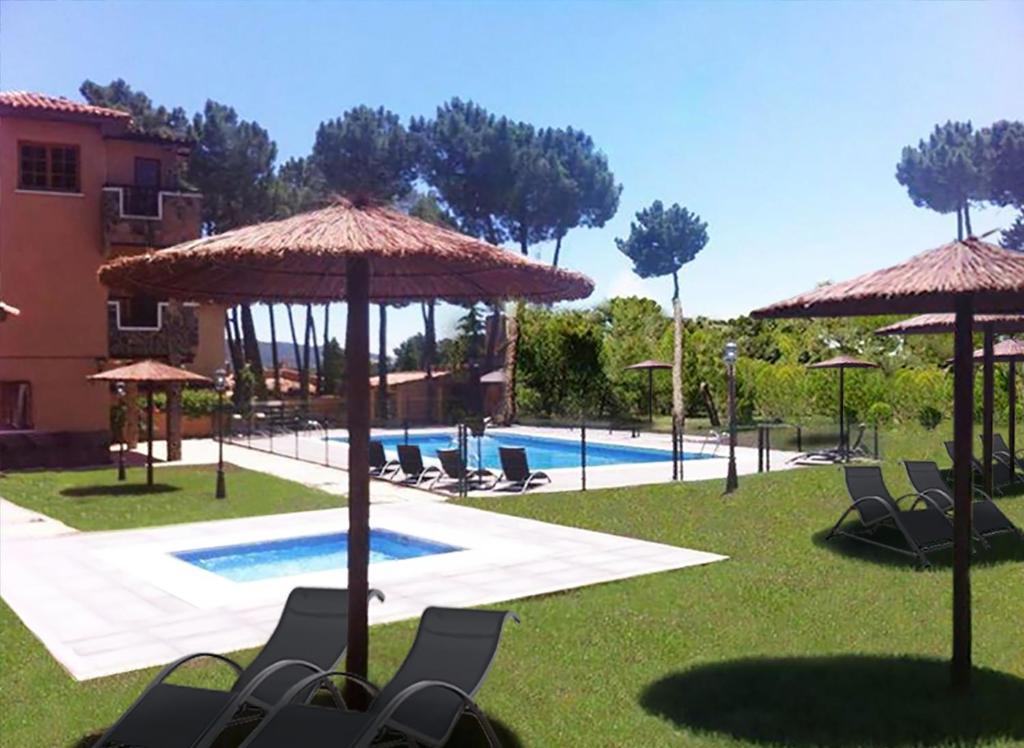 昆卡La Villa Don Quijote的一个带椅子和遮阳伞的度假村和一个游泳池