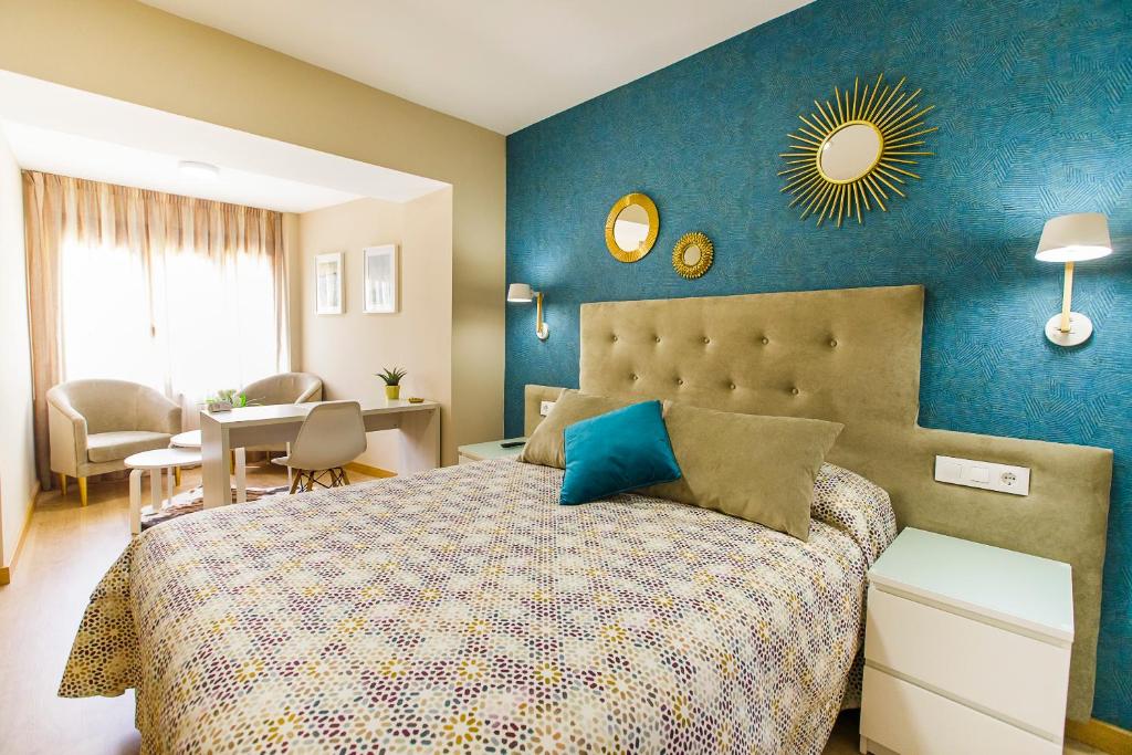 罗德里戈城Hospedería Castilla Plaza Mayor的一间卧室配有一张蓝色墙壁的床