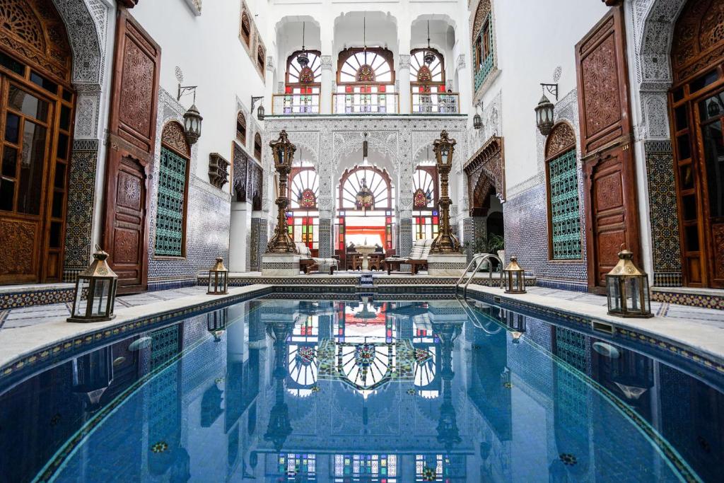 非斯里亚德蔓藤酒店及Spa的一座室内游泳池,位于一座带大大厅的建筑内
