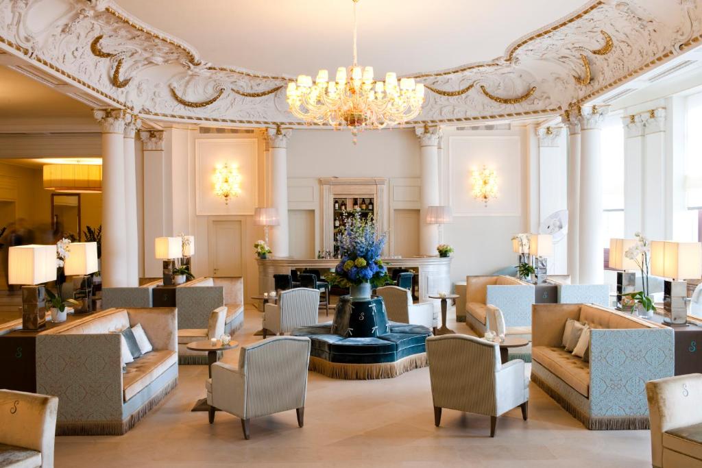 的里雅斯特里雅斯特萨瓦尔星际酒店的大厅,带有沙发和吊灯的酒店大厅