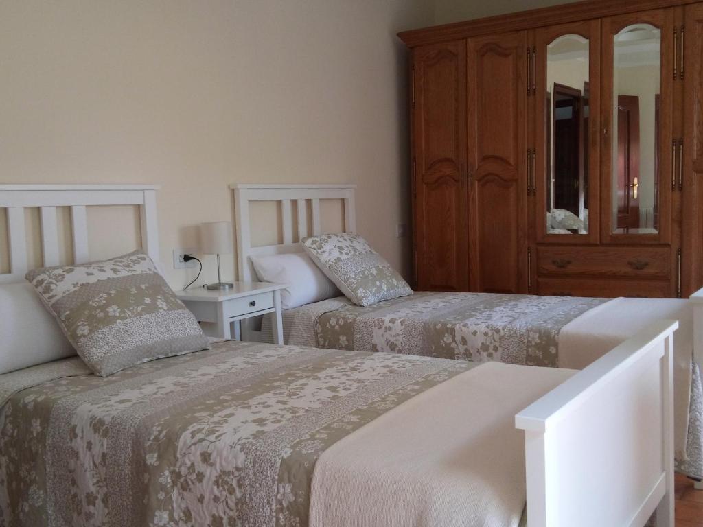 阿尔苏阿Casa Do Zoqueiro的一间卧室配有两张床和橱柜