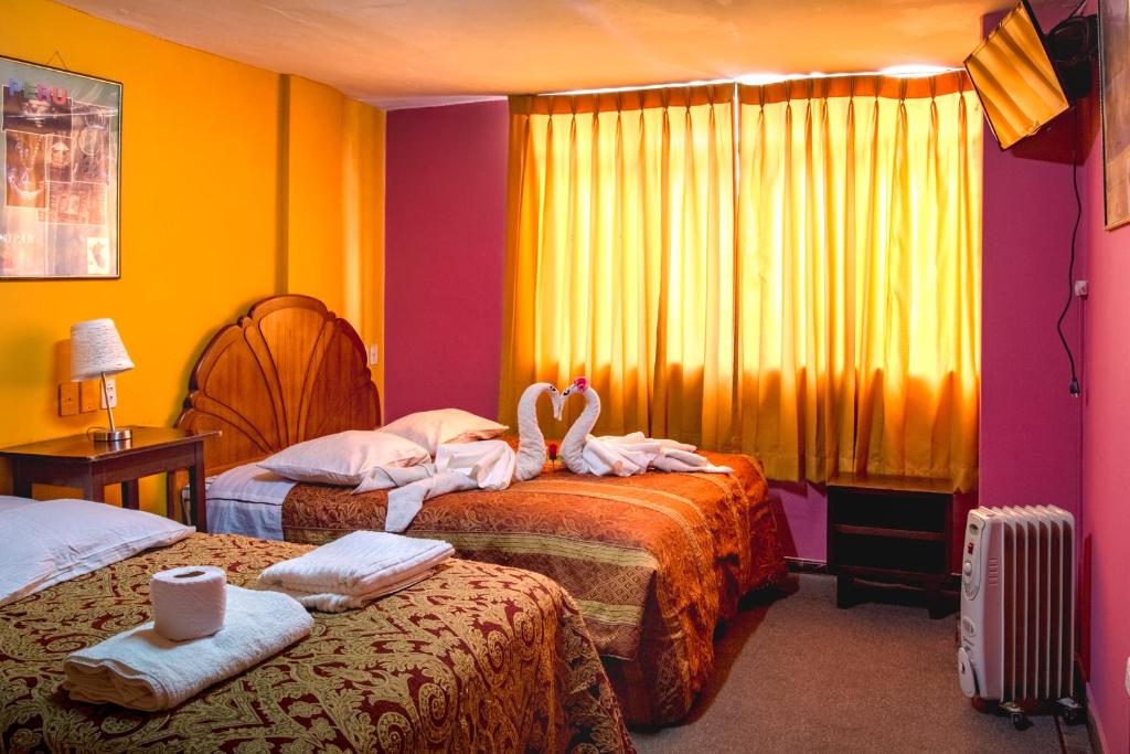 普诺圣女拉斯涅韦斯II旅馆的两张床铺,房间有两个天鹅