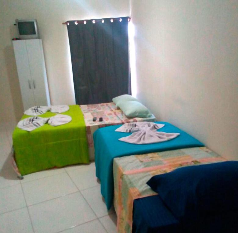 迈里波朗Pousada Oluap的两张睡床彼此相邻,位于一个房间里