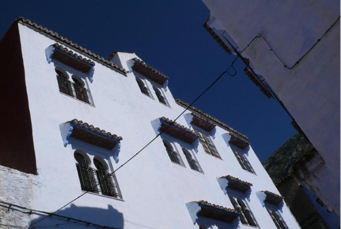 舍夫沙万拉斯艾尔玛阿酒店的一座高大的白色建筑,窗户在建筑的一侧