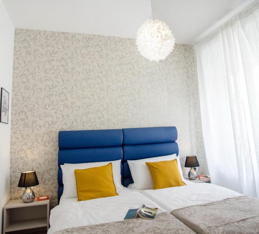 普拉San Martino Rooms的卧室配有蓝色和白色的床以及黄色枕头