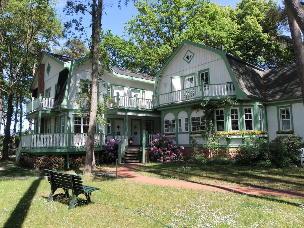 博尔滕哈根Landhaus Victoria的前面有长凳的绿色房子