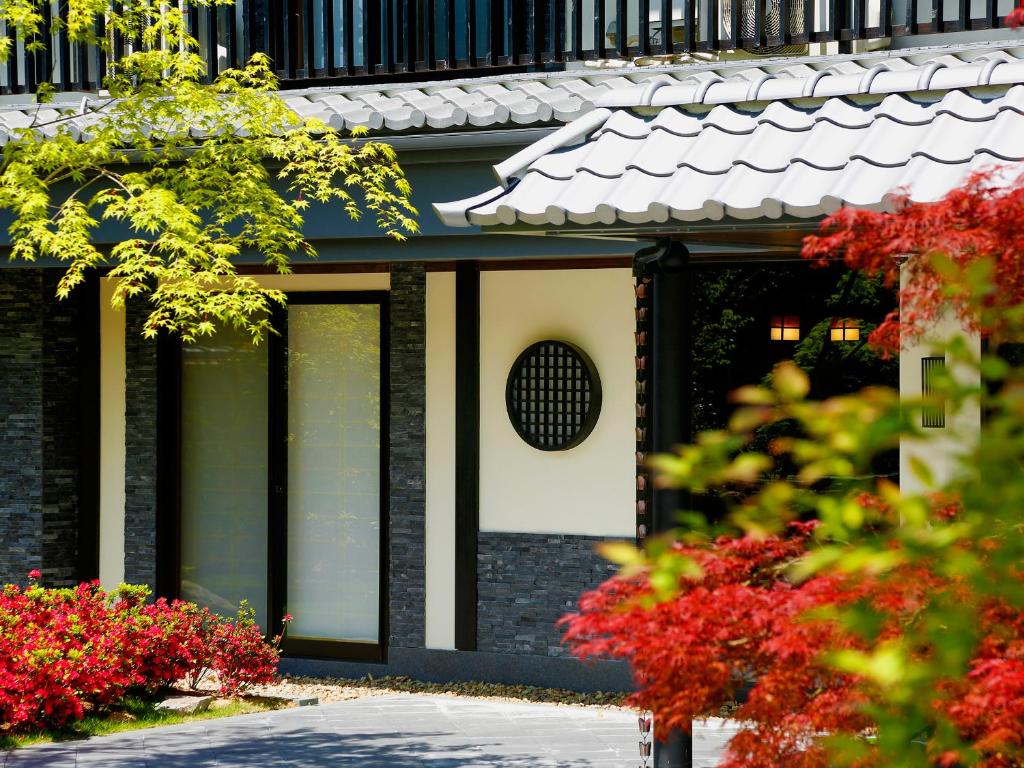 京都卡纳德日式旅馆的前方有红花的建筑