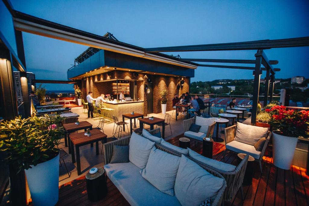 贝尔格莱德传统酒店的一个带沙发和桌子的屋顶露台和一间酒吧