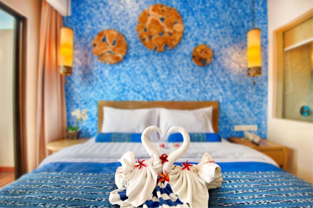 吉利特拉旺安吉利特拉旺安娜塔亚酒店的一间卧室,床上配有2条天鹅毛巾