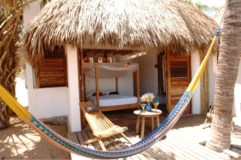 圣奥古斯蒂尼罗夙诺卡瓦尼亚斯德尔太平洋酒店的一张吊床位于带一张床的房间前