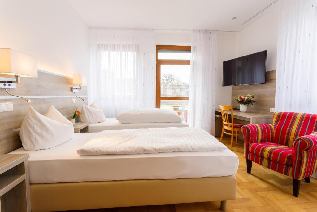 MichelauHotel Spitzenpfeil的酒店客房,配有两张床和椅子