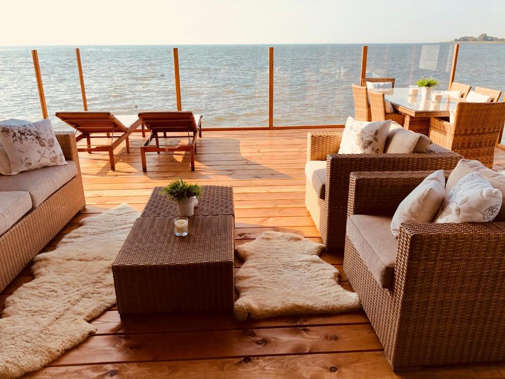 博文卡尔斯佩尔Vakantie Villa Markermeer的甲板上配有沙发和游艇上的桌子