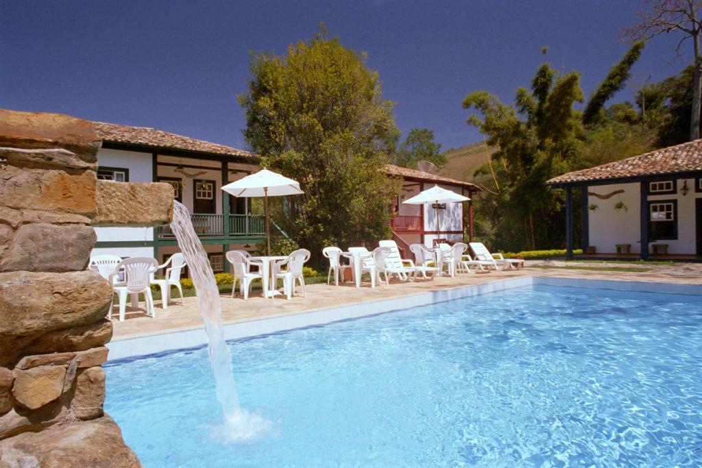 圣安娜-杜斯蒙蒂斯Hotel Solar dos Montes的一座房子前面的游泳池,喷泉