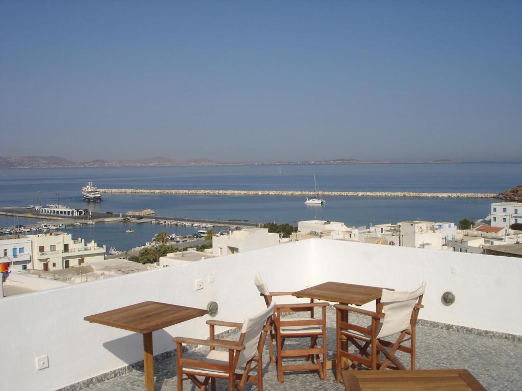 纳克索乔拉全景酒店的俯瞰大海的阳台配有2张桌子和椅子