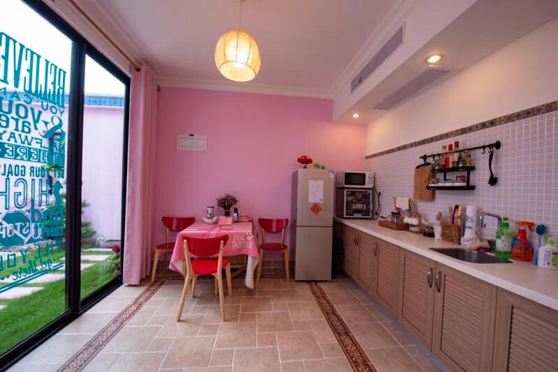 惠东万科双月湾独栋别墅的厨房配有桌子和冰箱