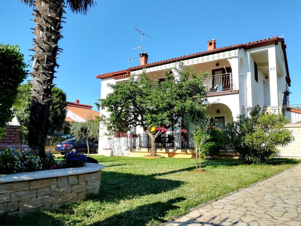 波雷奇Villa Nina Poreč的院子里有棕榈树的白色房子