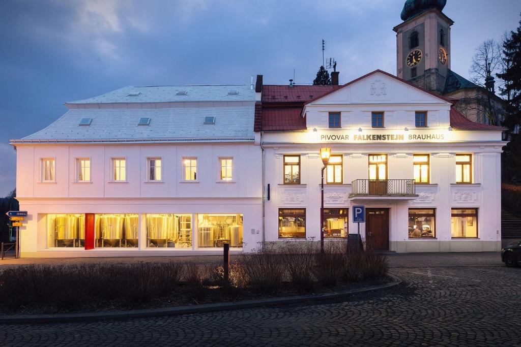 克拉斯纳利帕Pivovar Falkenštejn的一座白色的大建筑,灯火通明
