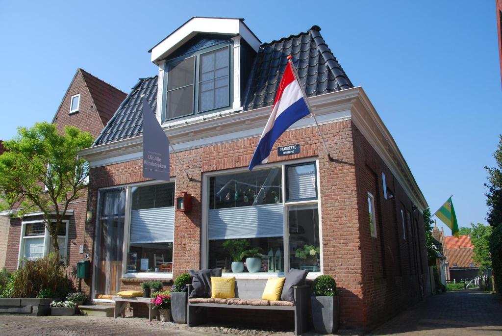 欣德洛彭Uit Alle Windstreken的前面有旗帜的建筑