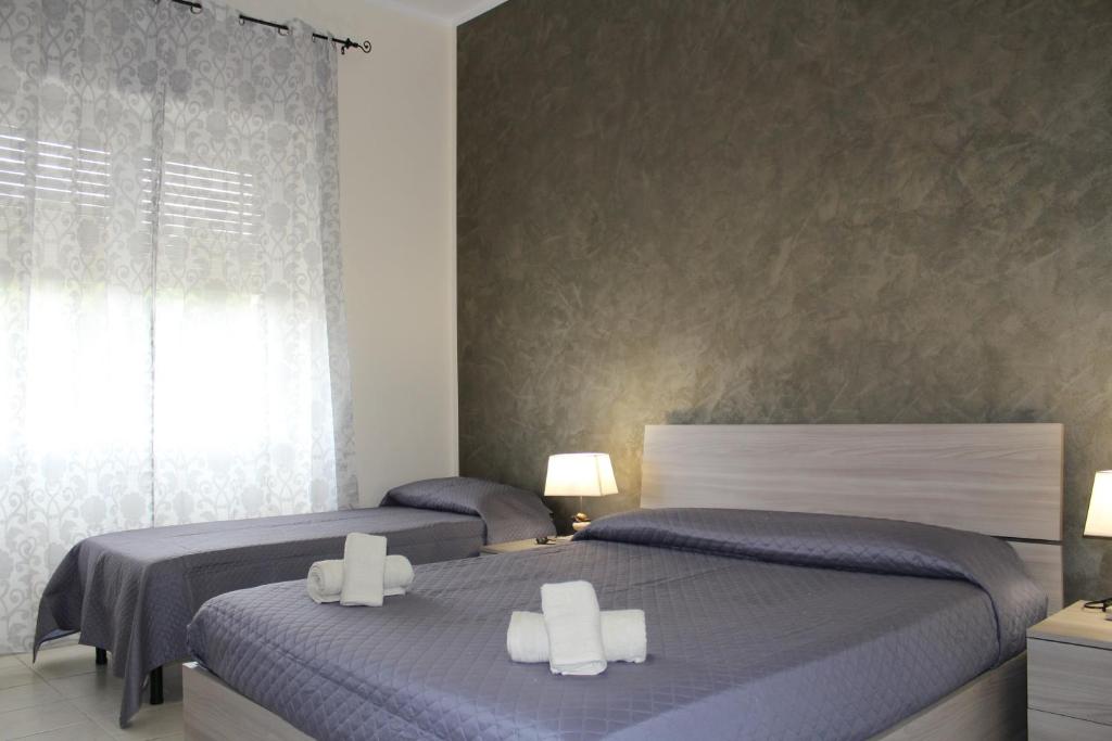 卡利亚里Cagliari 4u Self Check in的一间卧室设有两张床和窗户。