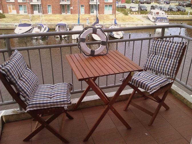 乌埃克尔明德Sealounge 239的阳台上配有一张木桌和两把椅子